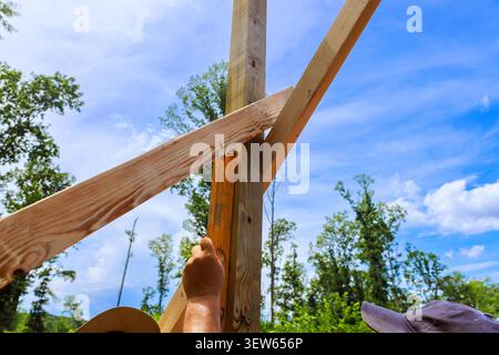 Two workers are engaged in construction, using level tool with wooden beams Stock Photo