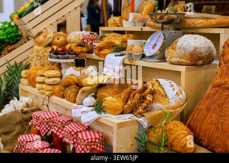 Breads, pastries, various baked goods are arranged on wooden shelves at local farm market. Stock Photo