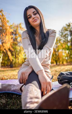 Young woman relaxing outdoors, writing notes on an autumn day Stock Photo