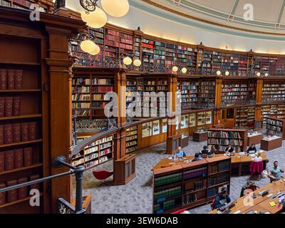 Victorian circular library, Picton Reading Room, Liverpool, England, showing multi-level wooden bookshelves and readers at desks. Stock Photo