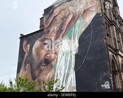 Large mural of a man pulling his face, created by Brazilian artist Liam Bononi in Liverpool, England. Stock Photo