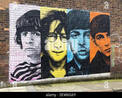 A colorful street art mural of The Beatles on a brick wall in Watkinson St, Baltic Triangle, Liverpool, England, featuring block portraits. Stock Photo