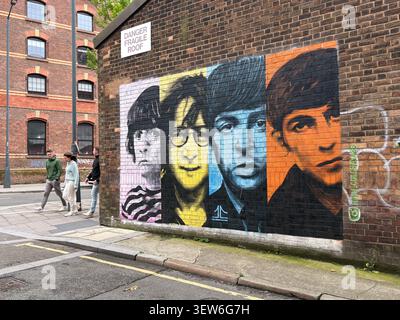 Painted brick wall mural of the Beatles by John Culshaw on Watkinson Street in Liverpool, featuring multi-colored portraits of the band members. Stock Photo