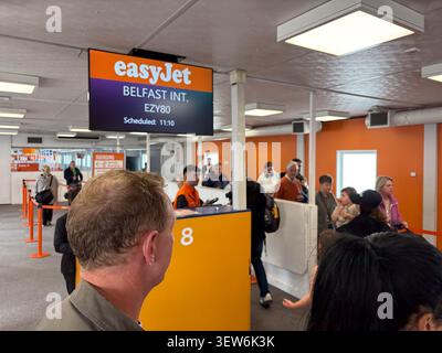 Passengers queuing at an easyJet boarding gate inside Liverpool Airport. Stock Photo