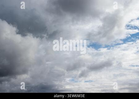 Dramatic Overcast Sky with Heavy Grey Clouds and Blue Patches Stock Photo