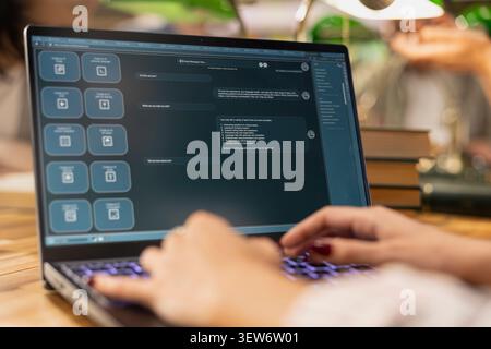 Close up of student uses AI virtual assistant on laptop with chatbot interface, showing digital learning and study assistant technology for modern education in library environment. Stock Photo