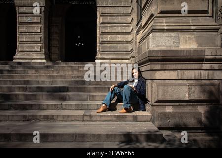 Young woman smiling sitting on stone stairs architecture Stock Photo