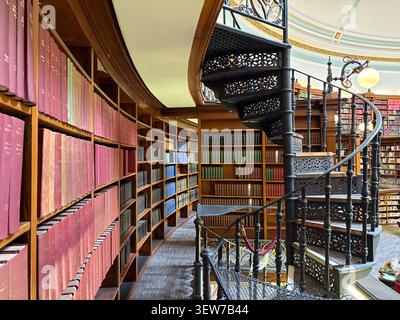 Victorian iron spiral staircase in the Picton Reading Room, Liverpool Central Library, Liverpool, UK, featuring domed architecture and library shelves Stock Photo