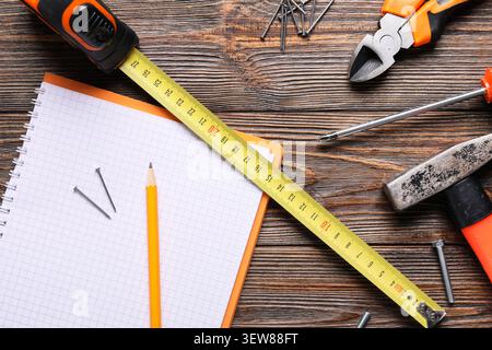 Construction tools and notebook on wooden table Stock Photo