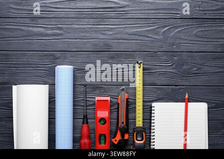 Construction tools and blueprint on dark wooden surface Stock Photo