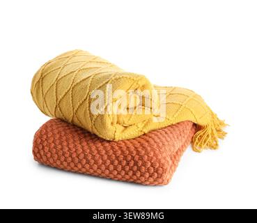 Folded yellow and orange knitted blankets on white background Stock Photo