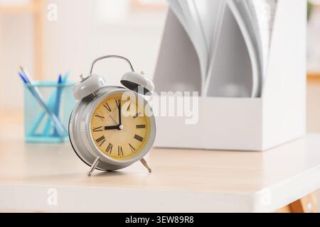 Vintage alarm clock on office desk with stationery Stock Photo