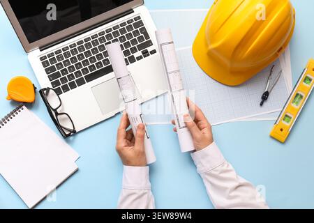 Architect reviewing blueprints with laptop and construction tools Stock Photo