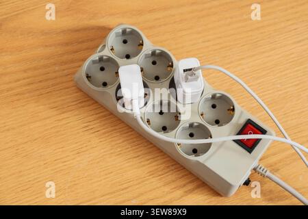 Power strip with two USB chargers on wooden surface Stock Photo