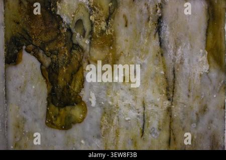 Detailed macro background of a luxury quartzite or marble stone slab surface with natural veins. This abstract mineral texture with olive green, gold, Stock Photo