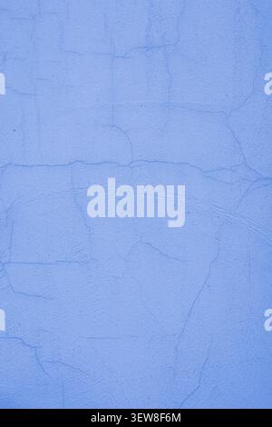 Full frame background of a light blue painted plaster wall with a network of fine cracks and weathered details. This textured cement surface shows sig Stock Photo
