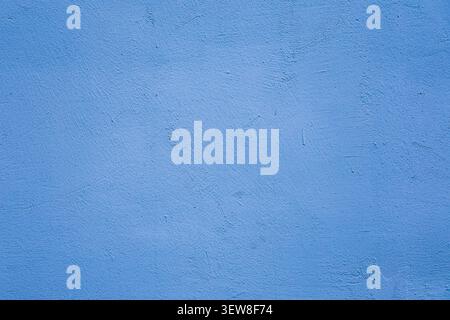 Full frame texture of a vibrant blue painted stucco wall with fine grains and subtle imperfections. This rough cement plaster background is perfect fo Stock Photo