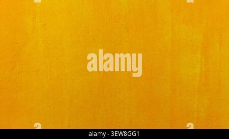 Close-up photo of a vibrant yellow painted wall texture with subtle imperfections and brush strokes Stock Photo