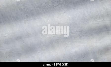 Abstract background of soft shadows and sunlight patterns cast on a textured white concrete wall Stock Photo
