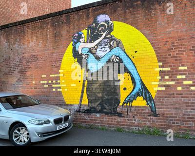 Street art mural of an underwater diver holding a mermaid on a brick wall in Cathedral Quarter, Belfast, Northern Ireland. Stock Photo