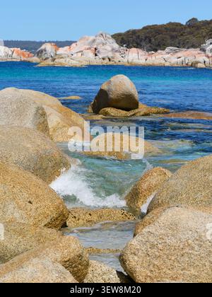 Vertical image of Bay of Fires with wave hitting the beach of white sand Stock Photo