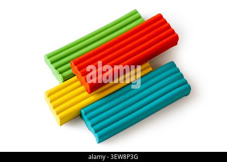 Multi-colored plasticine bricks on a white background. Childrens plasticine close-up. Stock Photo