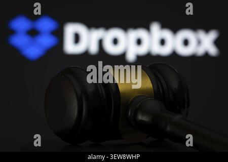 Dhaka, Bangladesh - 12 May 2026: A wooden judge's gavel is seen in front of the Dropbox logo displayed on a screen Stock Photo