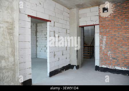Empty room interior build with white and red  bricks, plastering wall,  waterproofing floor,  metal door lintel. Stock Photo