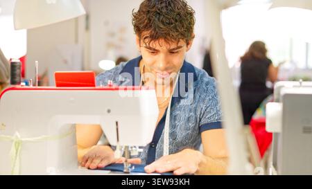 Tailor man sewing fabric in fashion workshop Stock Photo