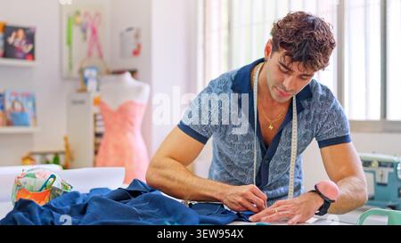 Fashion designer pinning fabric in sewing workshop Stock Photo