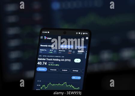 Smartphone displaying stock market information on a dark screen Stock Photo