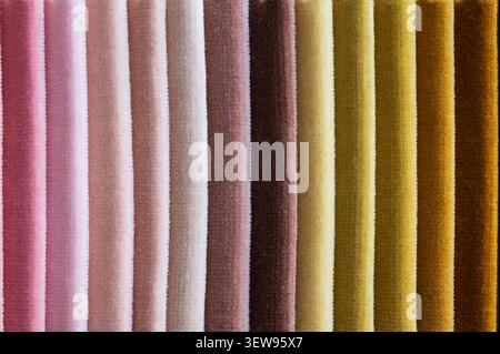 Close up of folded velvet fabric samples arranged in vertical stripes in earthy pastel colors from dusty pink to mustard yellow Stock Photo