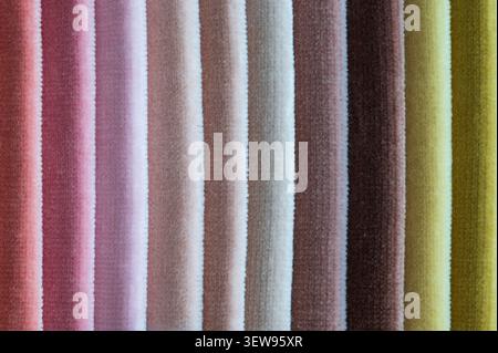 Macro close up of folded velvet fabric samples arranged in wide vertical stripes in earthy pastel colors from pink to mustard yellow Stock Photo