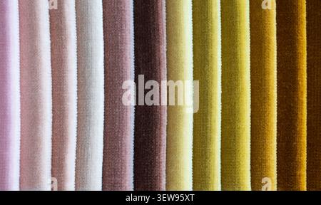 Close up texture of soft velvet fabric swatches in vertical stripes of pastel pink brown and warm yellow colors Stock Photo