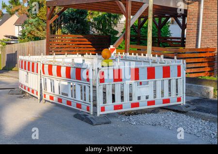 White and red construction barriers with warning light blocking a road. Stock Photo