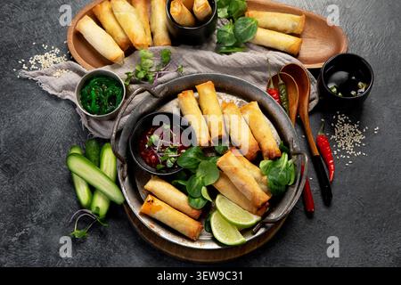 Crispy spring rolls with vegetables for appetizer on a dark background. Asian snack concept. Top view. Stock Photo