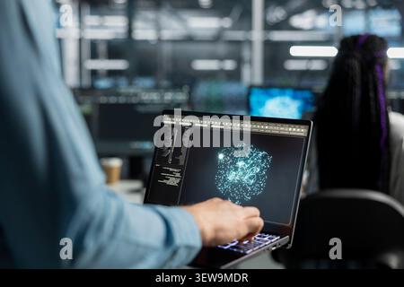 System operator uses a laptop computer in a data center to support automation monitoring and reliable server workflows. Stock Photo