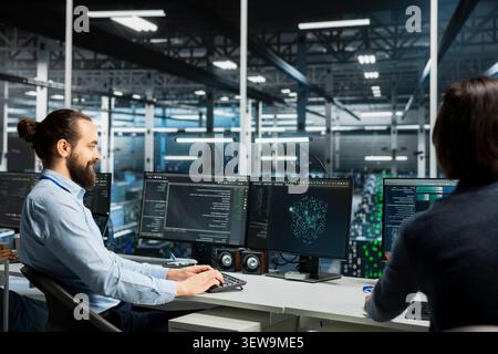 Data center team uses a desktop computer in a data center to manage AI systems and optimize server infrastructure. Stock Photo