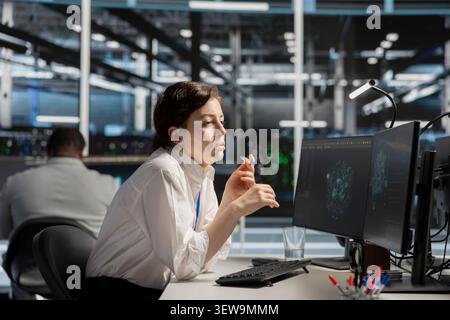 System administrator uses a digital device in a data center to manage AI simulation and optimize server infrastructure. Stock Photo