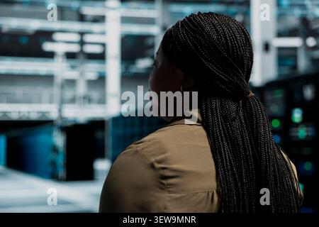 Data center technician uses a desktop computer in a data center to support failure detection and reliable server workflows. Stock Photo