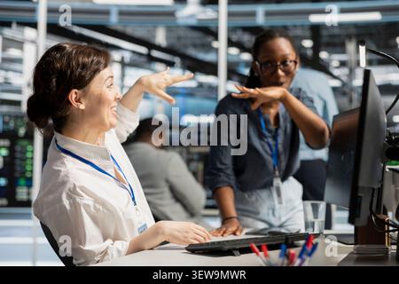 Cheerful engineering team celebrates improved system results in a data center after improved performance and completed server operations. Stock Photo