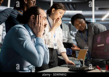 Data center programmers review cyber threat alerts in a data center while working to protect infrastructure from security breaches. Stock Photo