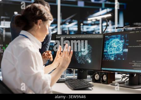 Data center colleagues collaborate on coding and AI automation scripts while reviewing server infrastructure together. Stock Photo