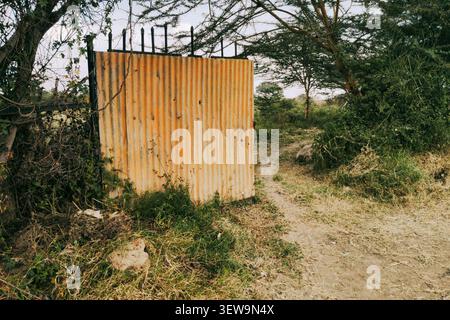 Rusty Corrugated Iron Gate on a Dirt Path in Syokimau, Kenya Stock Photo