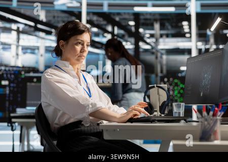 Computer scientist uses a computer to run diagnostics, update servers and check infrastructure performance. Stock Photo