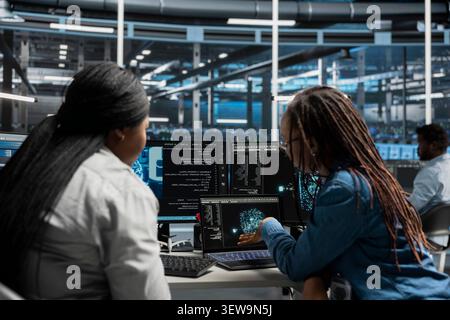 System administrator reviews artificial intelligence systems and machine learning processes inside a data center. Stock Photo