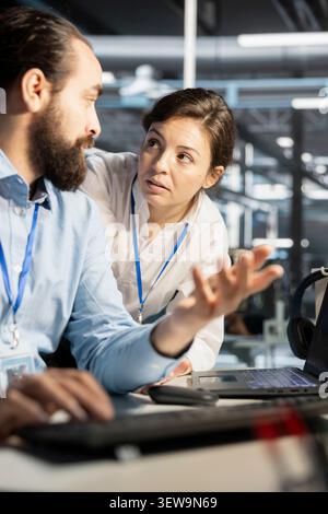 Data center colleagues collaborate on technical analysis and server infrastructure management inside a high-tech facility. Stock Photo
