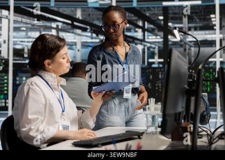 Data center team works together on diagnostics, maintenance tasks and server equipment performance checks. Stock Photo