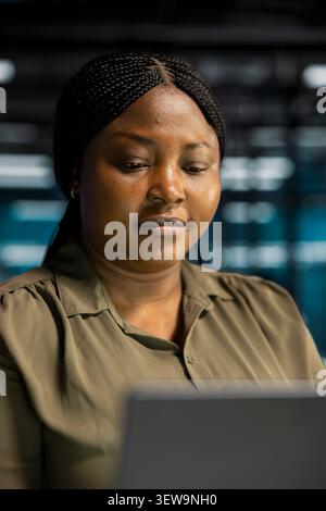 Data center engineer inspects server infrastructure, performs maintenance checks and reviews equipment diagnostics. Stock Photo