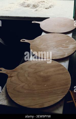 Three pizza serving boards in a pizzeria kitchen isolated Stock Photo